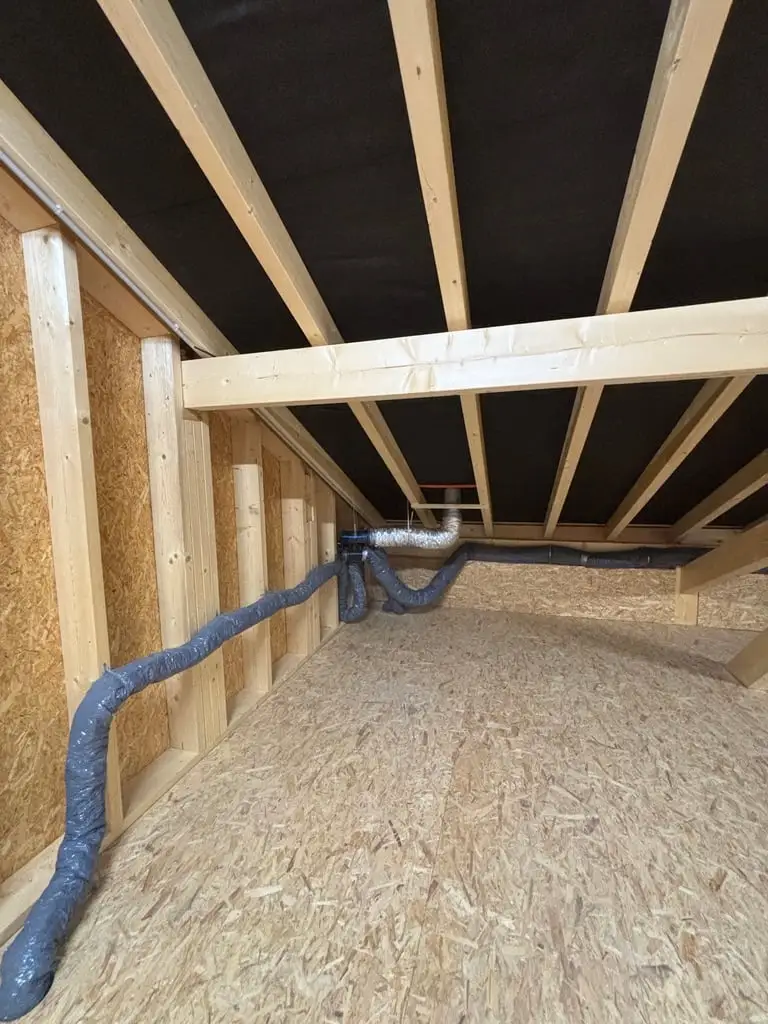 Réseau de ventilation passé sous un plancher à poutres bois