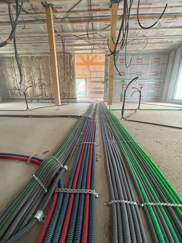Faisceau de gaines ICTA avant coulage de la chape dans une maison à ossature bois